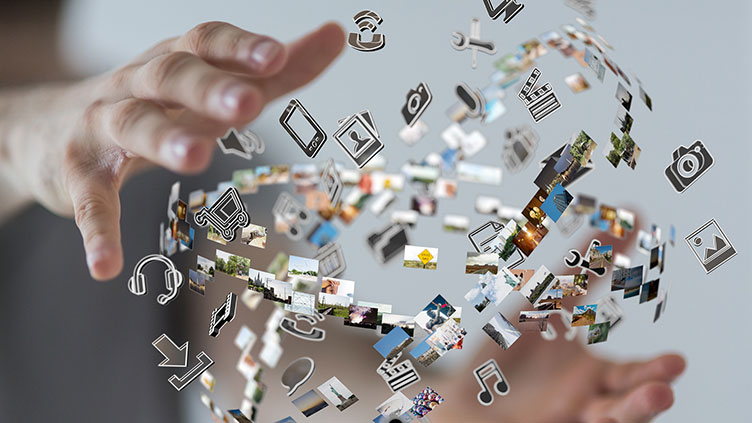 Digital 2020: Unterwegs zur digitalen Arbeitswelt. Das Foto zeigt zwei Hände und einen Ball aus Icons von Technikgeräten.