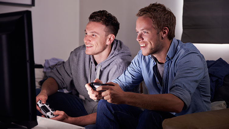 Zwei Männer sitzen vorm Bildschirm und halten einen Controller einer Spielekonsole in den Händen. Nur ein Ego-Shooter?
