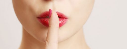 Eine Frau hält sich einen Finger an die Lippen