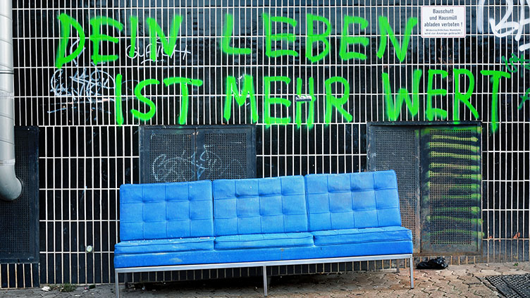 Graffiti "Dein Leben ist mehr wert" über einem Sperrmüll-Sofa; Symbolbild für das Thema Werte am Deutschen Katholikentag