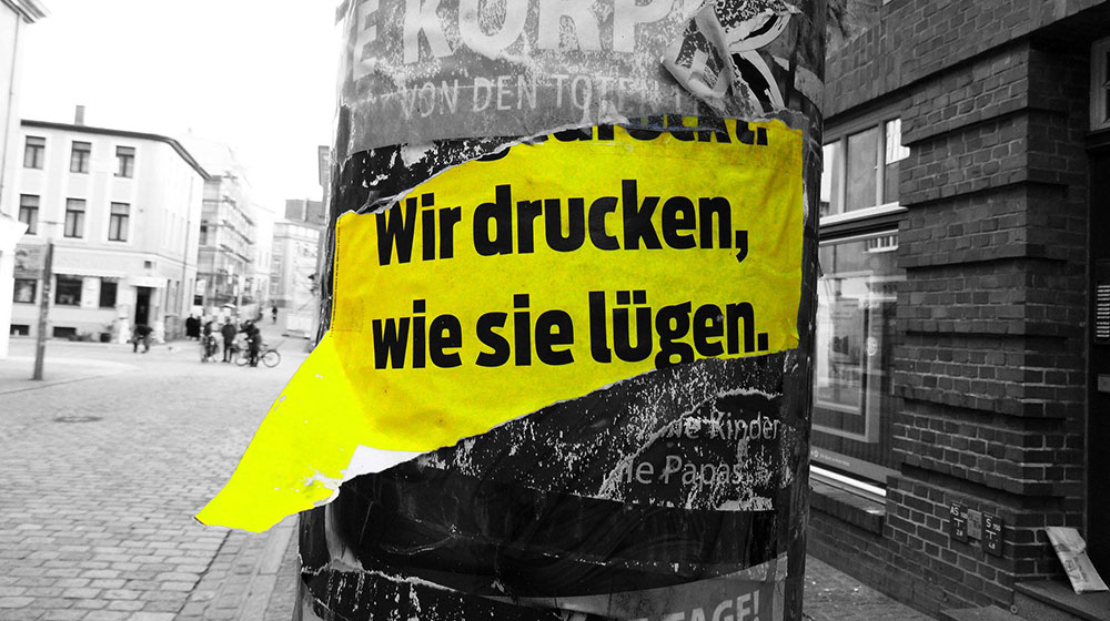 Plakat-Ausriss "Wir drücken, wie sie lügen"