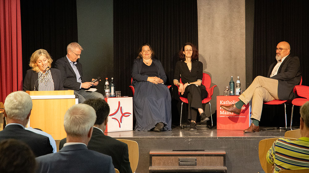 Symposium "KI und Soziale Arbeit" am 15.05.2025 in der KH Mainz - Begrüßung durch die Vorsitzende von forum sociale, Prof.'in Dr. Nicole Biedinger. Auf dem Podium (v.l.n.r.): Prof. Dr. Nils Köbel (Moderation), Prof.'in Dr. Doris Aschenbrenner, Dr. Nora Schleich, Prof. Andreas Büsch